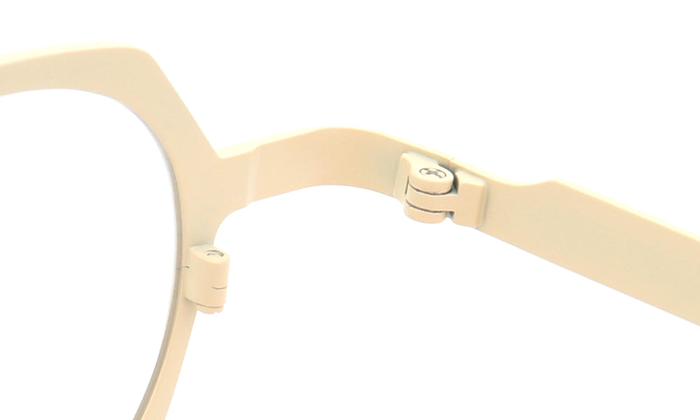 Inner hinge of cream colored titanium eyeglasses