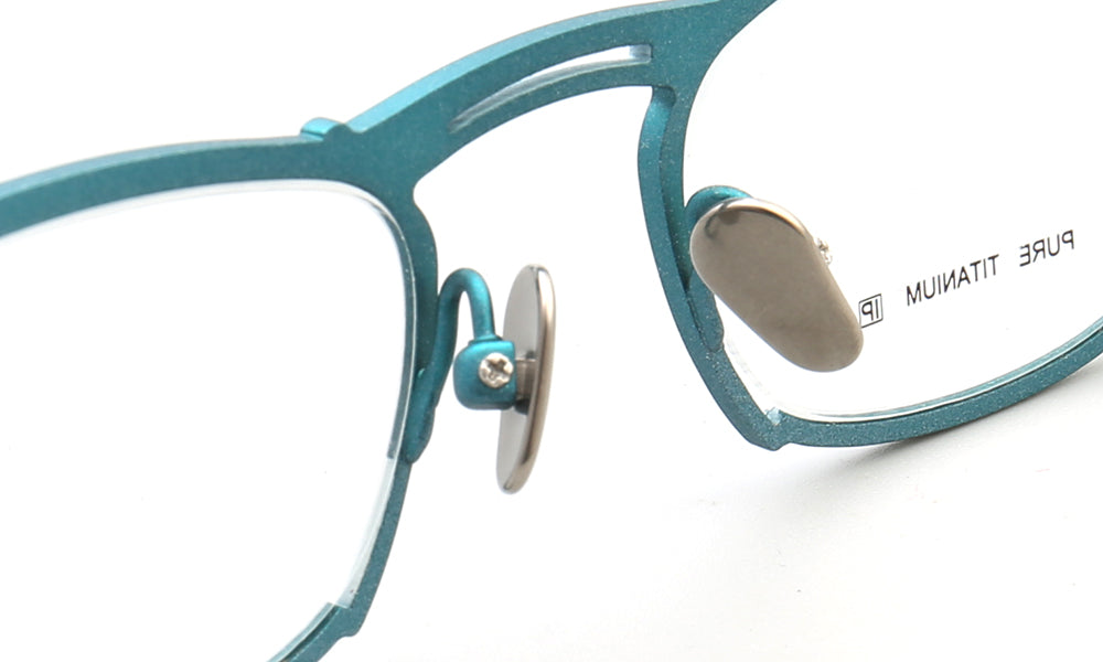 Nose pads of teal colored titanium glasses