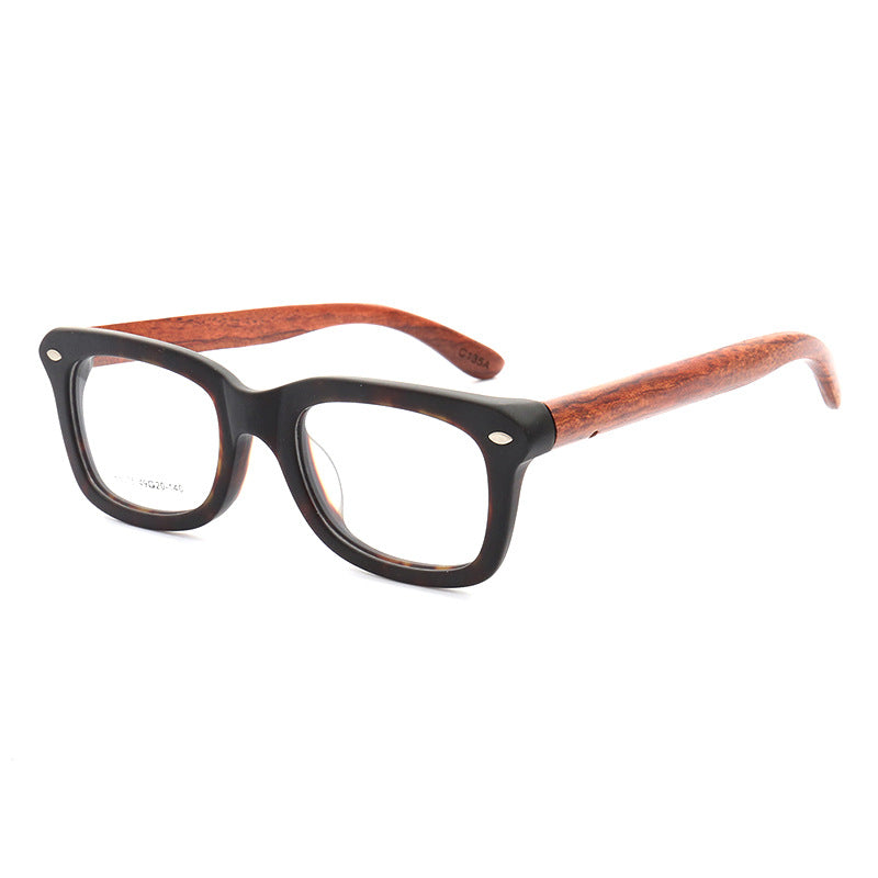 A pair of tortoise shell patterned wooden eyeglass frames